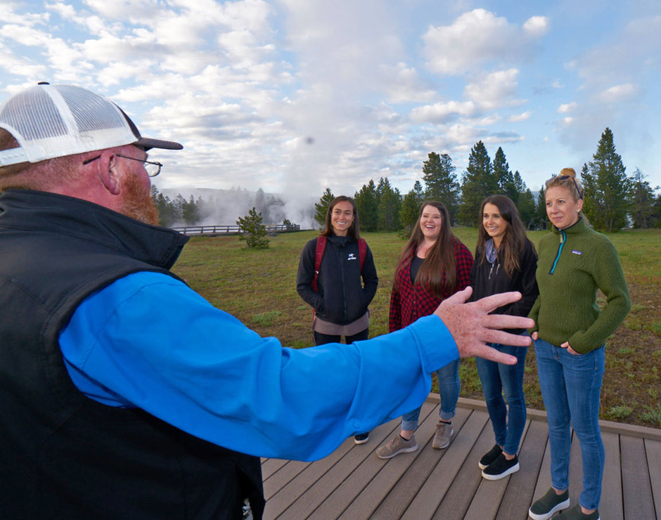 A group of Yellowstone tourists listens to an interpretive guide